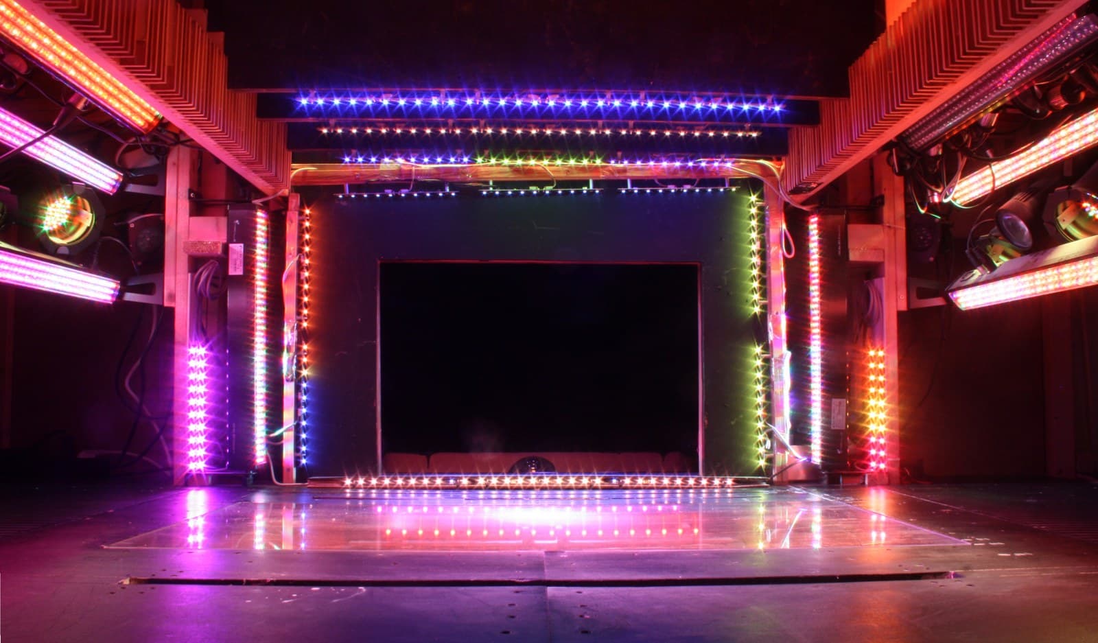 A modern theater stage lit with colorful LED lighting