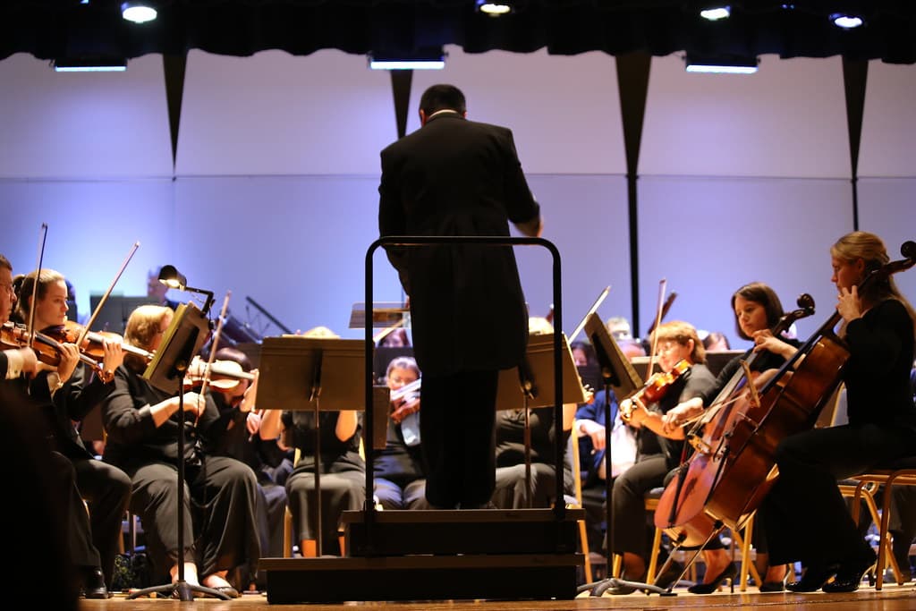 An orchestra performing on an outdoor stage