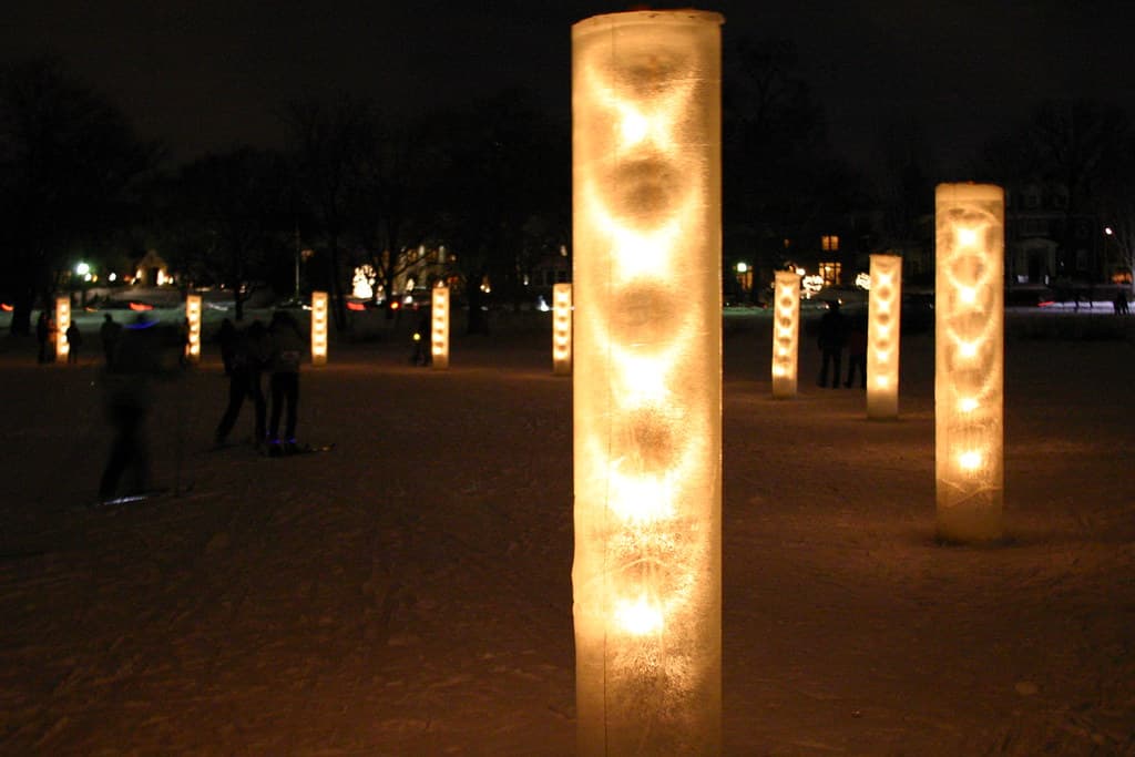 Ice luminaries glow on a frozen Minneapolis lake during a winter gathering
