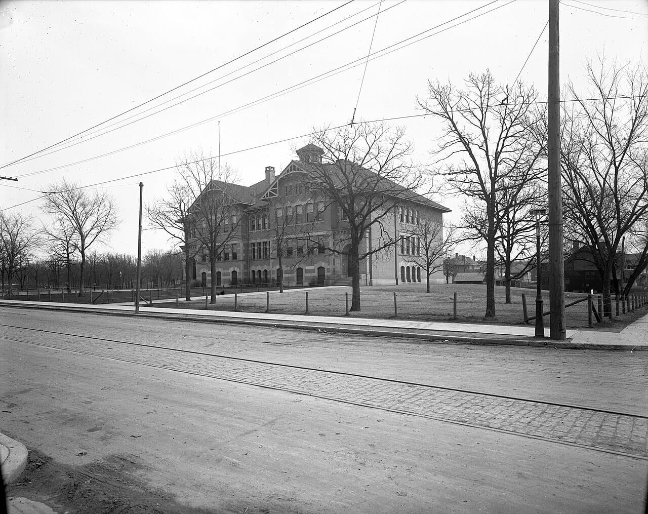 A historical photograph of Kenwood School in Minneapolis, the neighborhood's 1908 elementary building, seen from the street.
